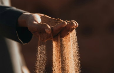 a-person-holding-sand-in-their-hands.jpg a person holding sand in their hands